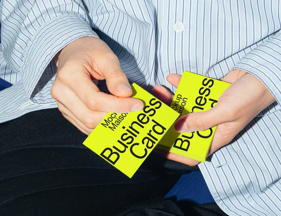 Hands holding yellow business cards
